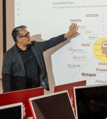 Instructor explaining typography design principles in a classroom setting